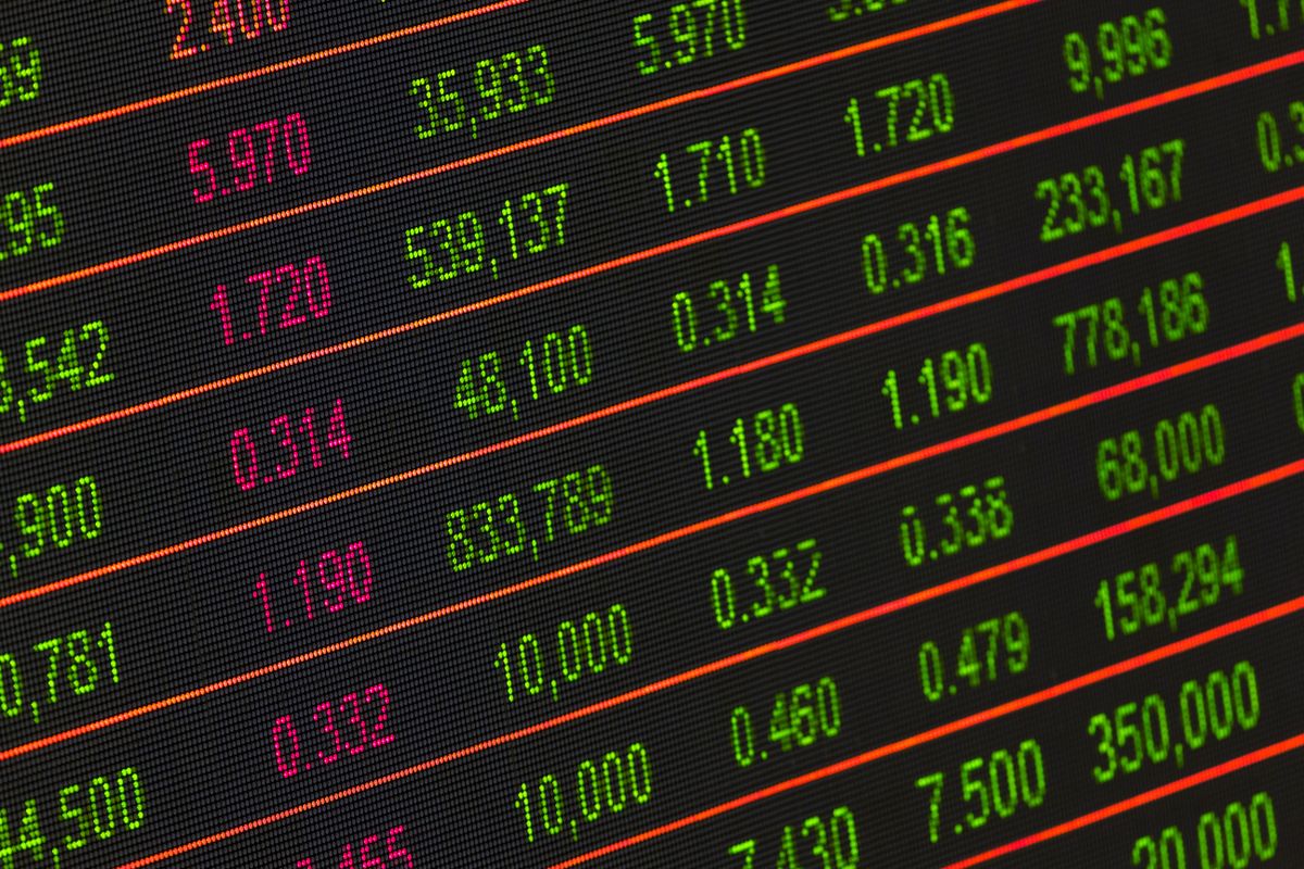 Close-up of an electronic stock market ticker board displaying rows of green and red price data